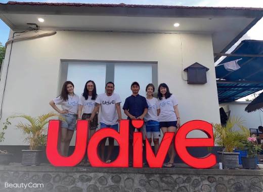 UDive Bali staff team photo at the UDive sign